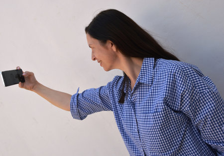 A girl with a smartphone browses the social pages of the siteの写真素材