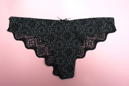 black lace panties on a pink background, close-up of lingerie