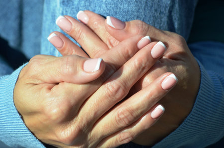Female hands with french manicure on nails. Women's hands with french manicure.