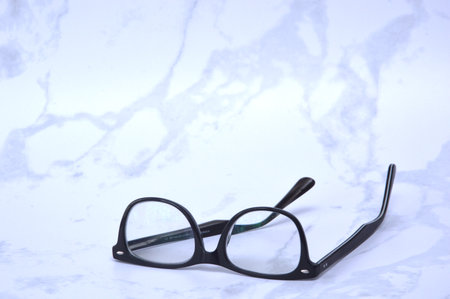 Black Eye Glasses on White Marble Background Great for Any Use.の写真素材