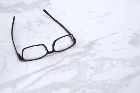 Eyeglasses on a white marble background. selective focus.
