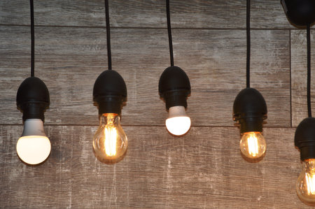 Vintage Incandescent Edison light bulbs on wooden wall background.の写真素材