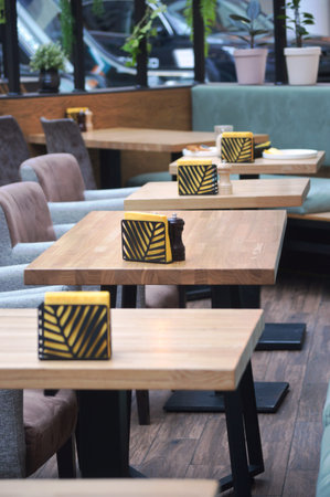 Interior of a coffee shop with tables and chairs in a rowの写真素材