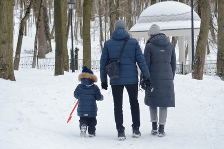 Mother and daughter walk in the park in winter. happy family.の写真素材