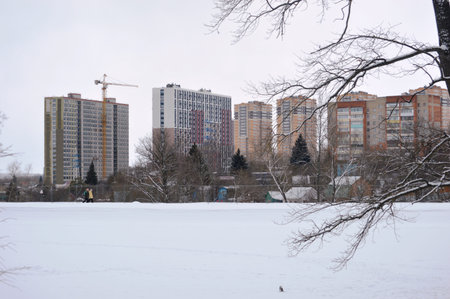 winter landscape of a frozen lake and multi-storey buildings on a cloudy dayの写真素材