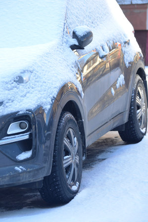 car covered with snow in winter, closeup of photo with shallow depth of fieldの写真素材