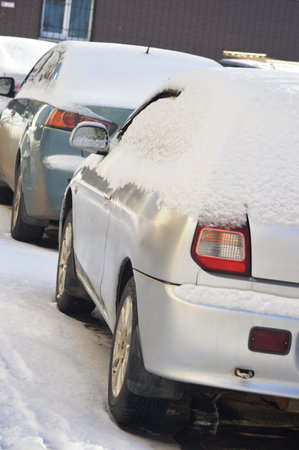 Cars covered with snow in a parking lot in the winter.の写真素材