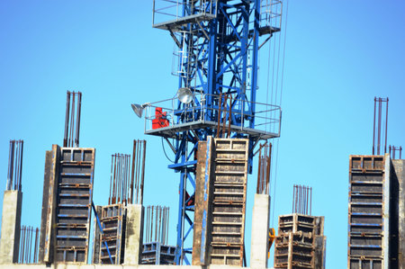 Crane and building under construction against blue sky, closeup of photo