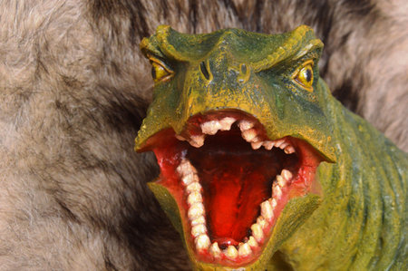 Close-up portrait of a dinosaur with open mouth and teeth.の写真素材
