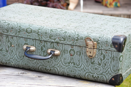 Old green suitcase on a wooden bench in the park. close-upの写真素材