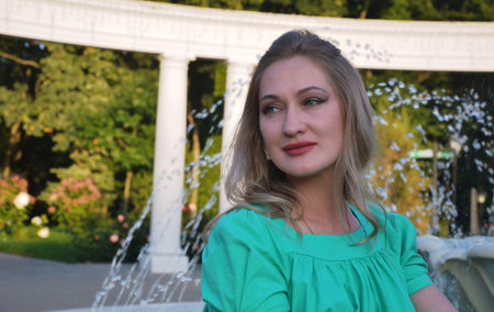 Portrait of a beautiful girl in a green dress in the parkの写真素材
