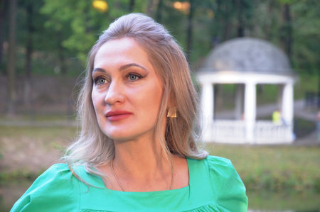 Portrait of a beautiful young woman in a green dress in the park