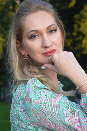 Portrait of a beautiful young blonde woman in a summer park.の写真素材