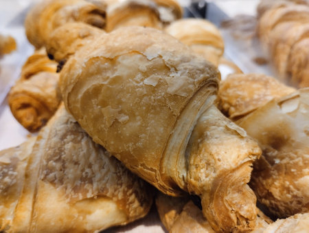 Freshly baked croissants on the counter of a bakery shopの写真素材