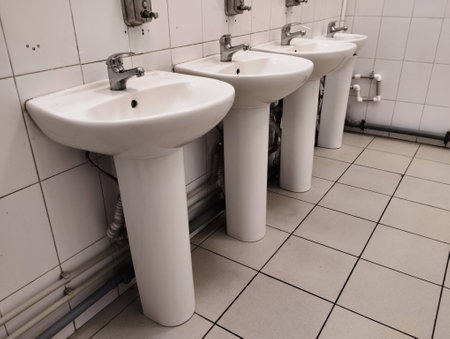 Row of white urine in a public toilet with tiles in the backgroundの写真素材