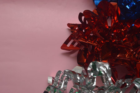 Red, blue and green bows on a pink background with copy space