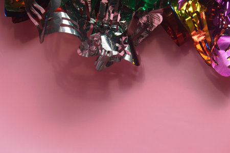 colorful confetti and ribbons on pink background, top viewの写真素材