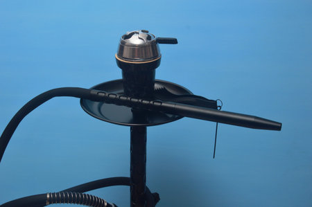 Modern black hookah on a blue background. Close-up.