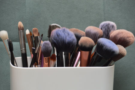 Makeup brushes in a white vase on a gray background.の写真素材