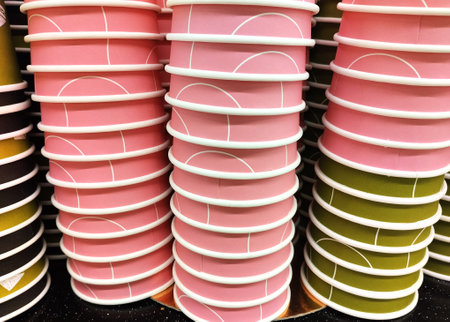 Stack of colorful paper cups on shelf in store, close-upの写真素材