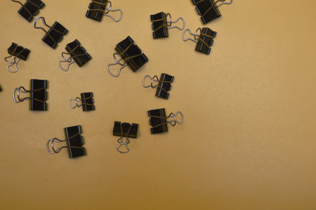 Black paper clips on a yellow background. Top view. Copy space.の写真素材