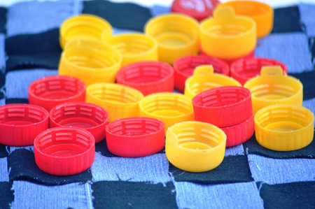 Colorful plastic bottle caps on a blue checkered tablecloth
