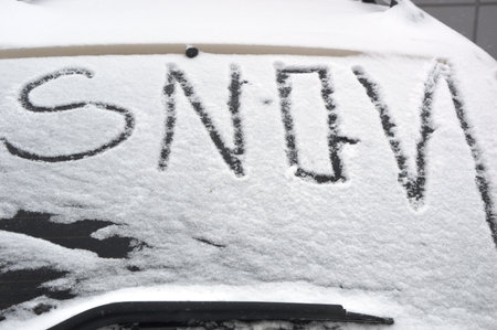 Snow on the windshield of a car with the inscription in the snowの写真素材
