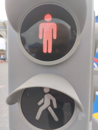 Traffic light with a man and a woman in the background.