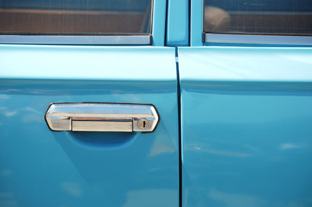 Close-up of the door of a blue old american car