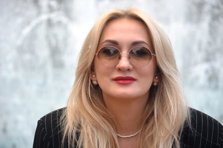 Portrait of a beautiful young woman with blond hair in sunglasses.の写真素材