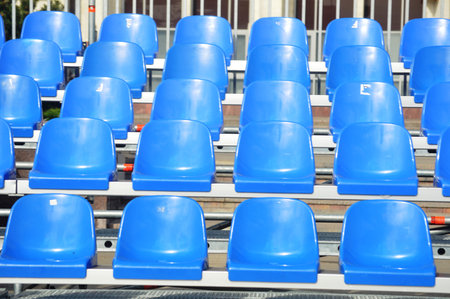 Blue plastic seats on a sports tribune in the stadium, close-up