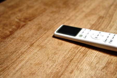 Remote control on a wooden table. Selective focus and shallow depth of field.