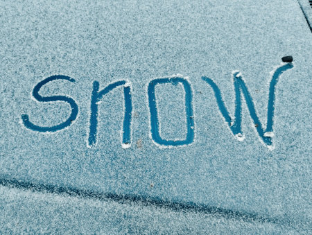 The word snow written on the car's windshield, winter background.の写真素材