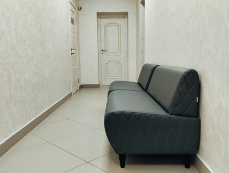 Interior of a hotel corridor with a sofa and a white wall
