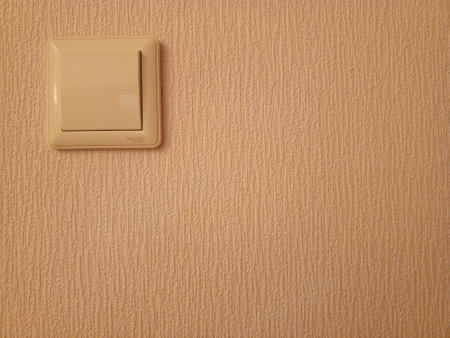 Light switch on the wall in the room, closeup of photoの写真素材