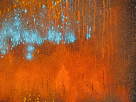 rusty metal plate with orange and blue paint. abstract background and textureの写真素材