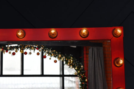Christmas lights on a red wooden door with a window in the background