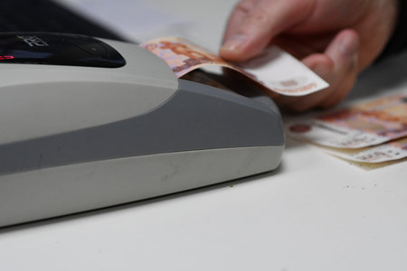 Credit card reader and euro banknotes on white background closeup.