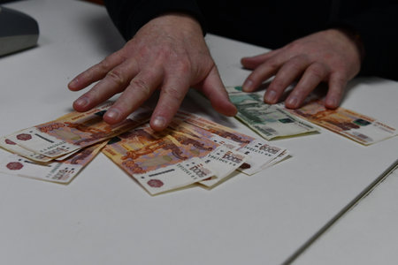Hands counting money on a table with a lot of banknotesの写真素材