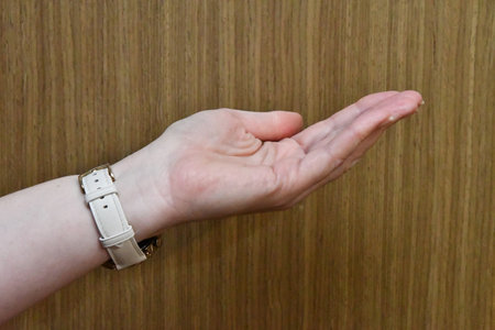 Female hand on the wooden background, closeup of photo with selective focusの写真素材