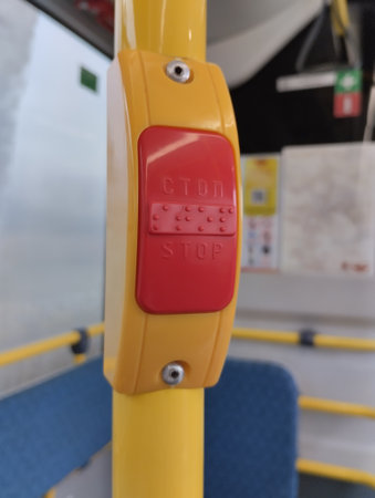 Interior of a bus with yellow seats and a red stop buttonの写真素材