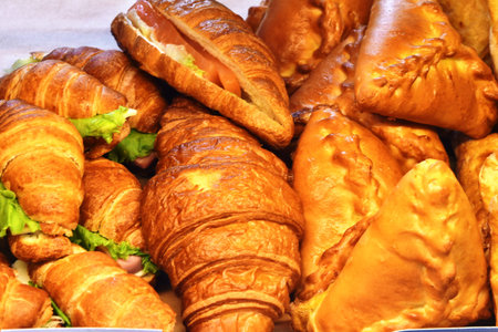 Croissants with ham and cheese on display at a market stall