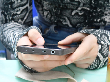 Woman using mobile smart phone in cafe, closeup. technology background