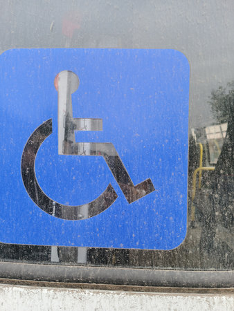 Disabled parking sign on the street in rainy day, close upの写真素材