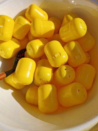 Yellow plastic objects in a bowl of water, closeup of photoの写真素材