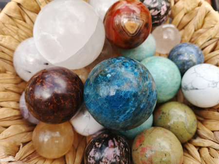 Marbles of different colors and shapes in a wicker basket.