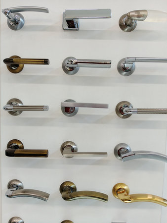 Set of stainless steel door handles on a white wall in a hotelの写真素材