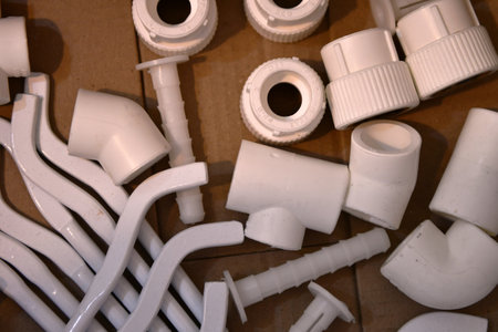 Plastic plumbing parts on a wooden background. Selective focus.の写真素材