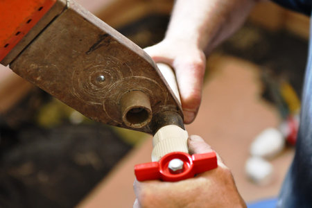 Hands of a carpenter working with a chisel in a workshop