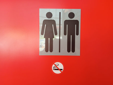 Toilet sign on a red wall. Toilet sign for men and women.